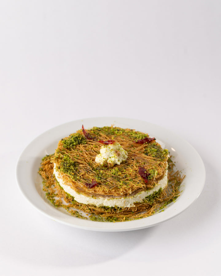 Traditional Esmaliye Plate with vermicelli dough, kashta filling, pistachio paste, and garnished with nuts on white plate