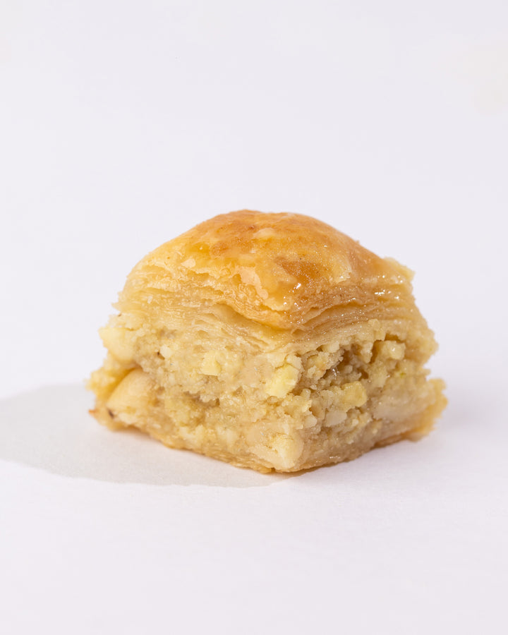 Close-up of a single Beklewa BL Cashew puff pastry crisp filled with crushed cashews and syrup glaze on top.