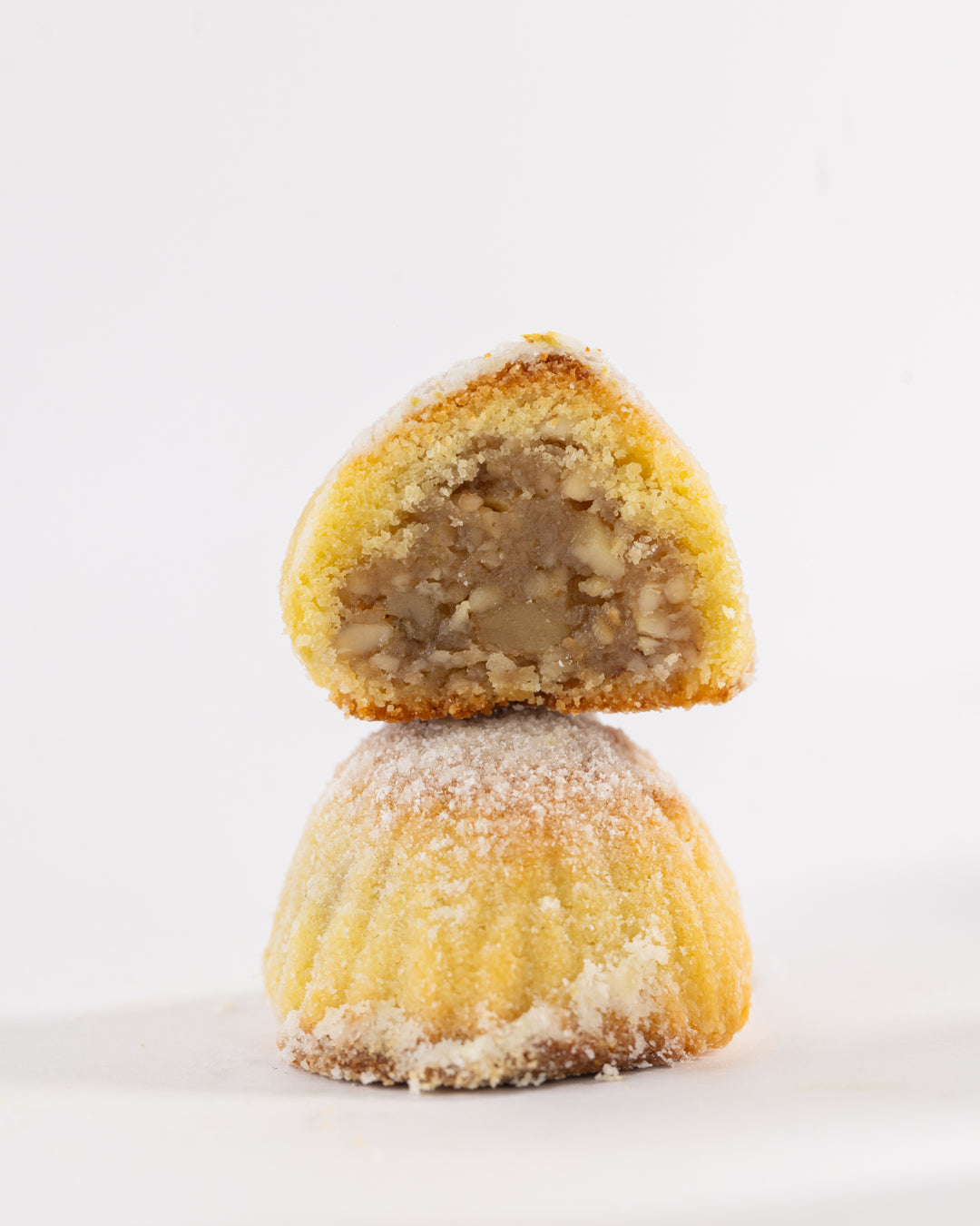 Traditional Maamoul Walnuts pastry with powdered sugar, showcasing rich walnut filling inside delicate dough.