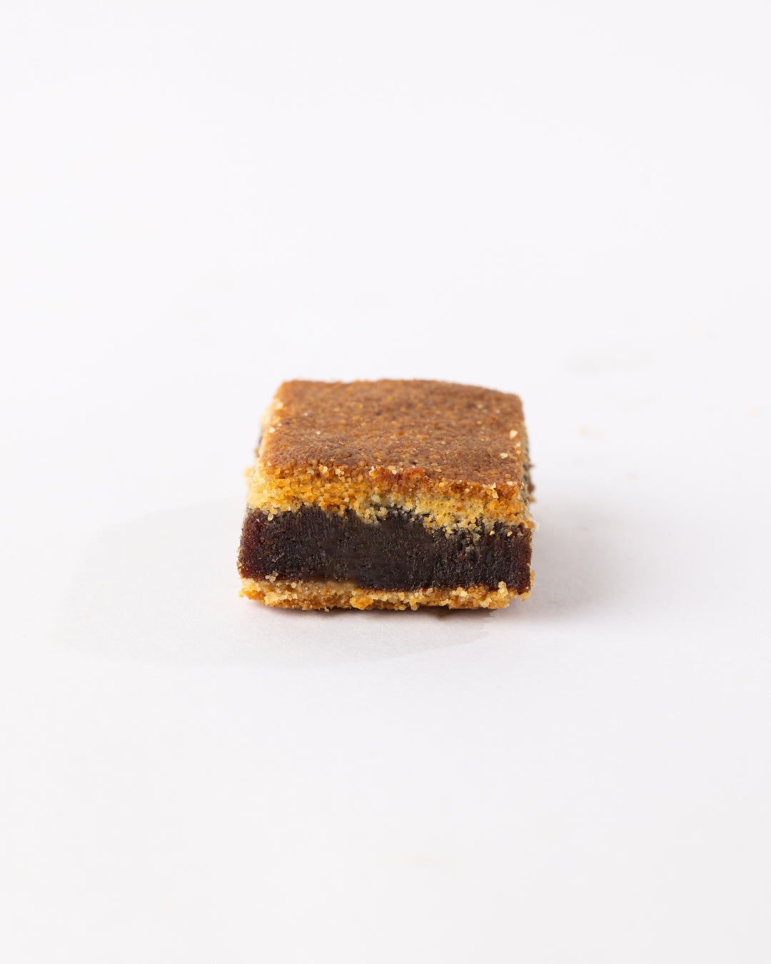 Square Maamoul dessert with double layered semolina dough filled with rich minced dates on a white background